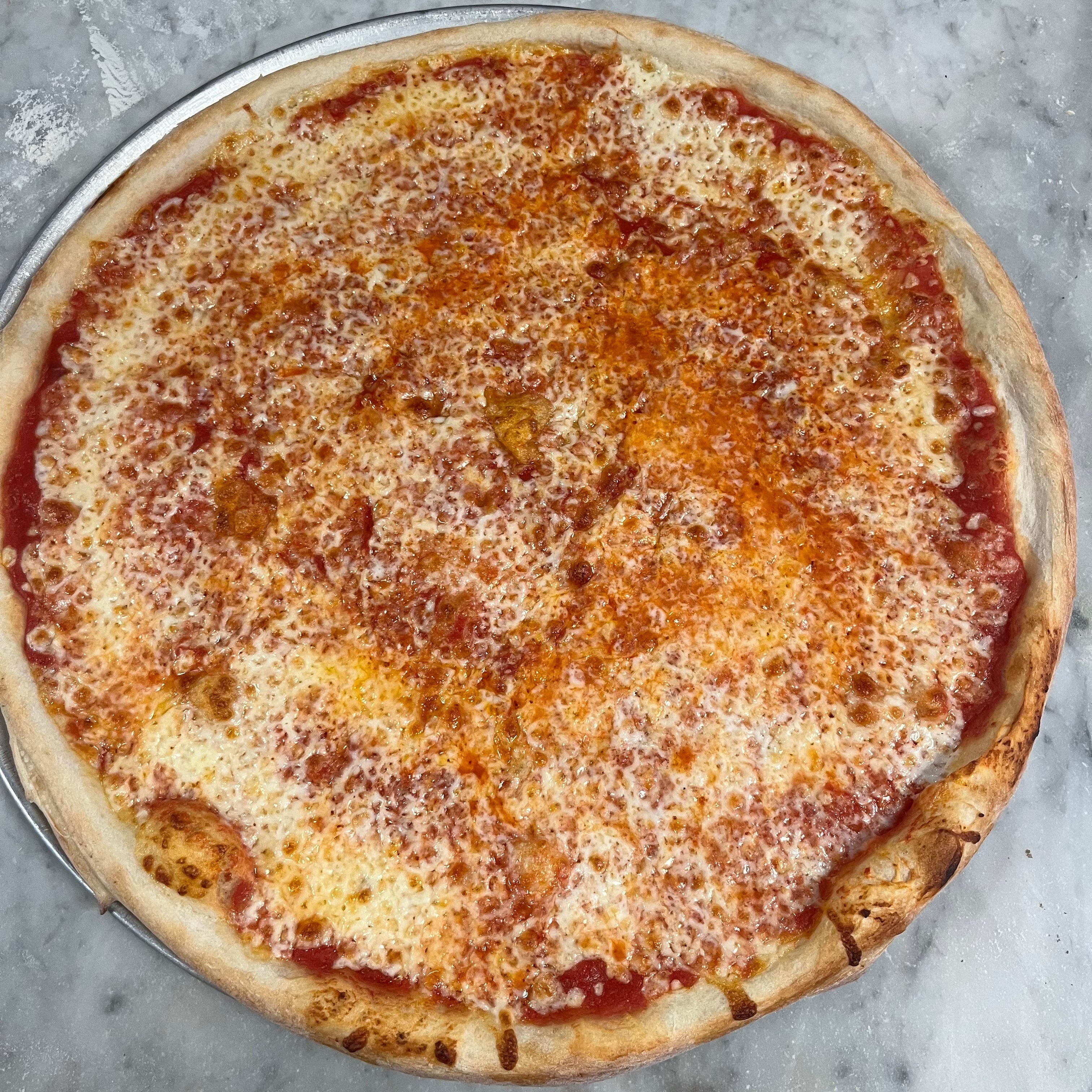 Pizza with tomato sauce and cheese on a marble countertop